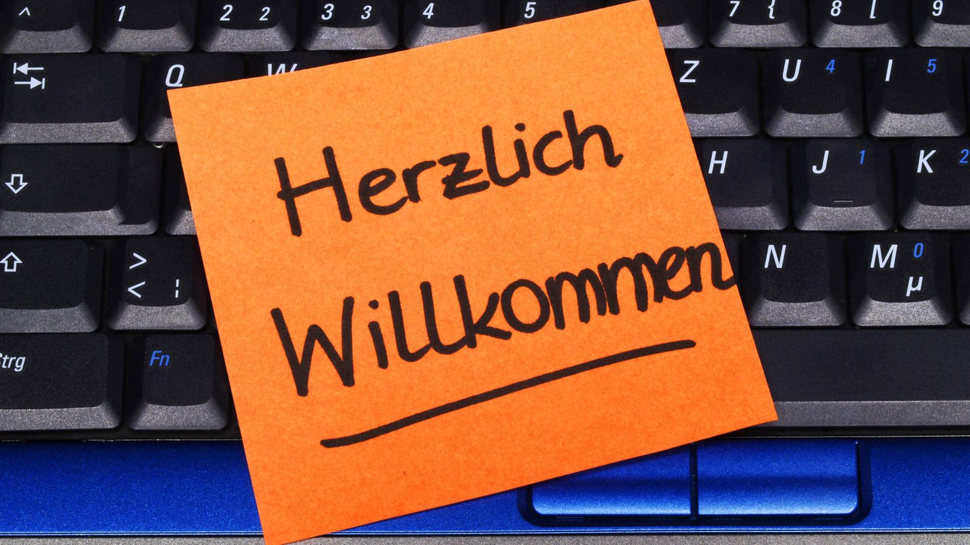 "Herzlich Willkommen" - Notizzettel auf einer Laptop-Tastatur "Herzlich Willkommen" - Notizzettel auf einer Laptop-Tastatur