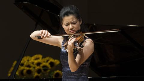 Eine junge Frau spielt mit ernstem Gesicht ihr Instrument.