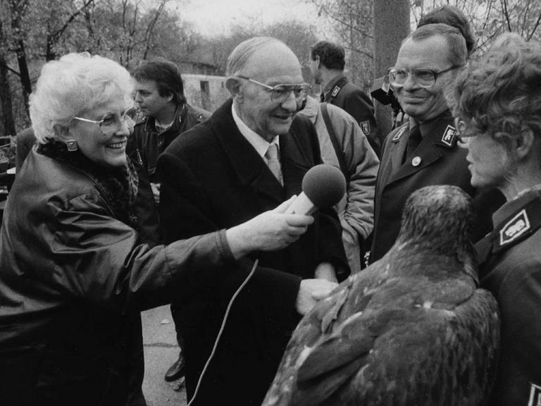 Der Berliner (Ost-Berlin) Tierpark-Direktor Heinrich Dathe und die Rundfunkreporterin Karin Rohn (Maria Rückert) bei einem Tierpark-Gespräch im Herbst 1990.