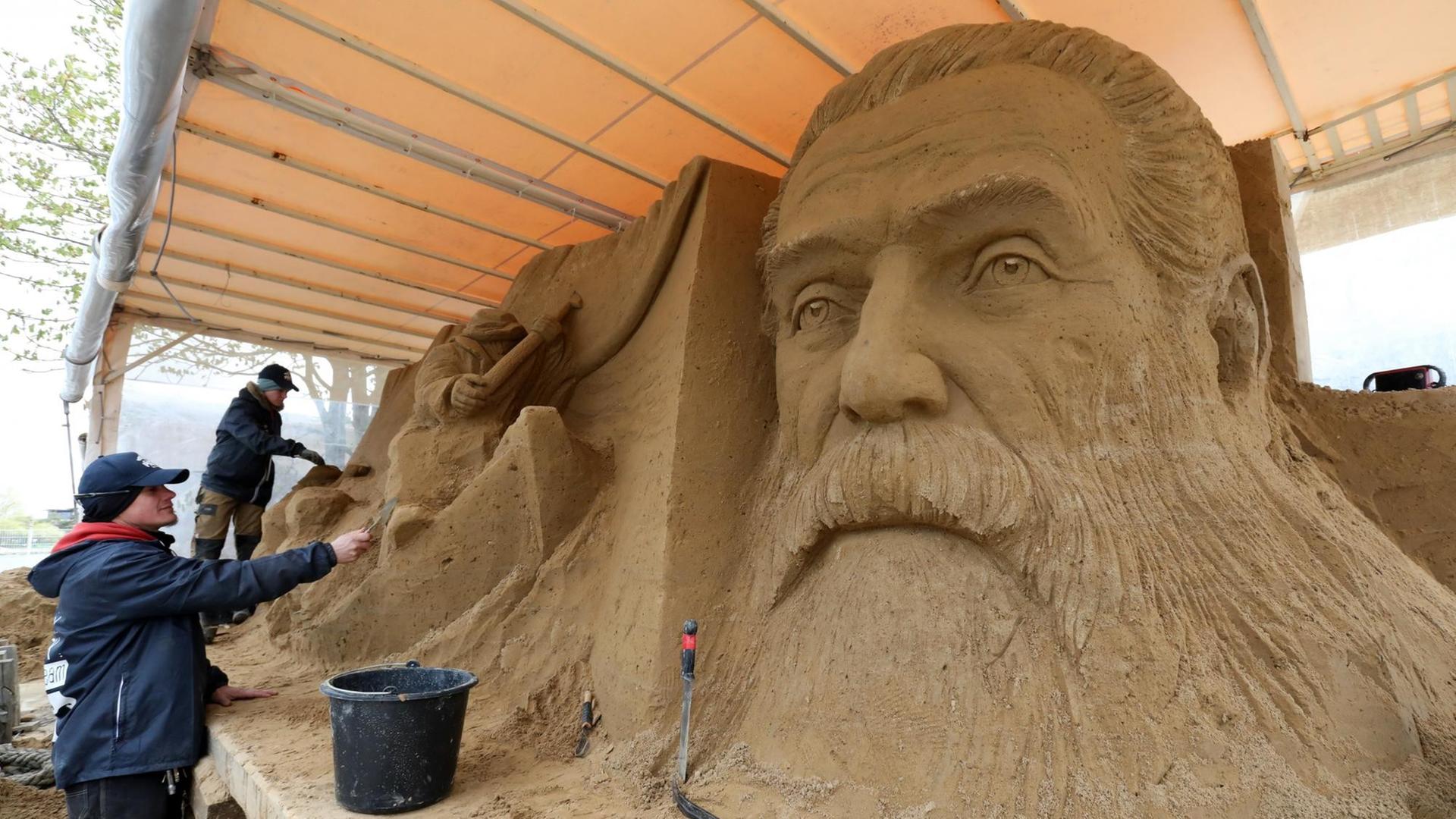 Donatas Mockus (l) und Inese Valtere-Ulande aus Lettland arbeiten am 18.04.2017 bei der 8. Warnemünder Sandwelt an ihren Skulpturen am Pier 7 in Warnemünde (Mecklenburg-Vorpommern). Sieben Künstler aus Lettland, Polen und Deutschland schaffen derzeit ihren Kreationen zum Thema «Moby Dick». Sie verarbeiten 300 Tonnen Sand zu bis zu sechs Meter breiten und drei Meter hohen Figuren. Gäste am Pier 7 können die Entstehung der Sandkunstwerke direkt verfolgen. Foto: Bernd Wüstneck/dpa-Zentralbild/ZB | Verwendung weltweit Donatas Mockus (l) und Inese Valtere-Ulande aus Lettland arbeiten am 18.04.2017 bei der 8. Warnemünder Sandwelt an ihren Skulpturen am Pier 7 in Warnemünde (Mecklenburg-Vorpommern). Sieben Künstler aus Lettland, Polen und Deutschland schaffen derzeit ihren Kreationen zum Thema «Moby Dick». Sie verarbeiten 300 Tonnen Sand zu bis zu sechs Meter breiten und drei Meter hohen Figuren. Gäste am Pier 7 können die Entstehung der Sandkunstwerke direkt verfolgen. Foto: Bernd Wüstneck/dpa-Zentralbild/ZB | Verwendung weltweit