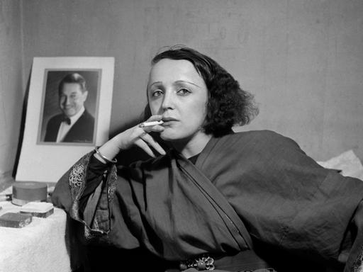 Die Sängerin Edith Piaf vor einem Bild von Maurice Chevalier im Jahr 1947.
