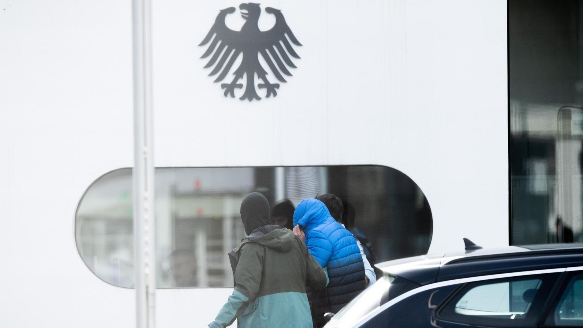 Eine Person wird von Polizisten in den Bundesgerichtshof gebracht. Eine Person wird von Polizisten in den Bundesgerichtshof gebracht.