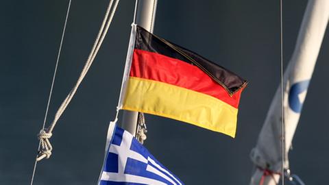 Deutsche und griechische Fahne wehen im Wind