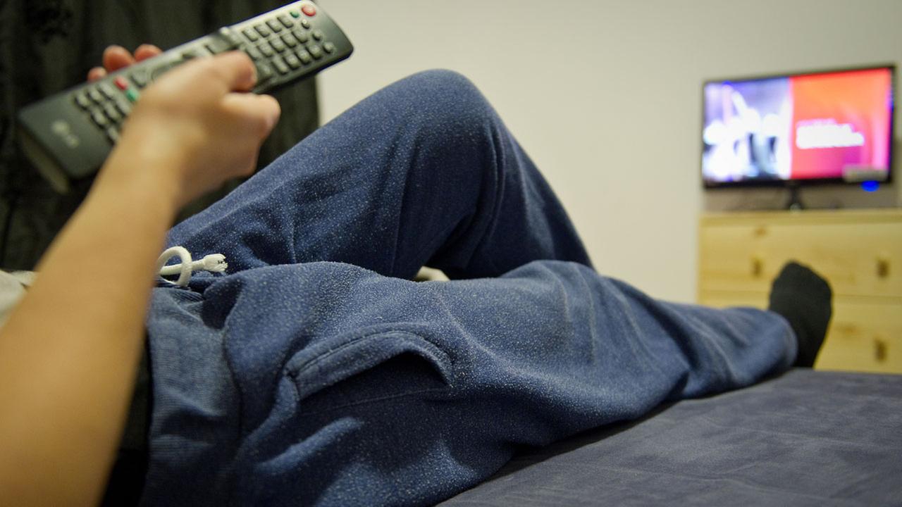 ILLUSTRATION - Eine junge Frau trägt am 20.01.2015 in Offenbach am Main (Hessen) vor dem Fernseher eine Jogginghose. Am 21.01.2015 ist Internationaler Jogginghosentag. Foto: Christoph Schmidt/dpa (zu dpa «Schlabberfreund trifft Modefreak: Typologie der Jogginghosenträger» vom 20.01.2015) | Verwendung weltweit ILLUSTRATION - Eine junge Frau trägt am 20.01.2015 in Offenbach am Main (Hessen) vor dem Fernseher eine Jogginghose. Am 21.01.2015 ist Internationaler Jogginghosentag. Foto: Christoph Schmidt/dpa (zu dpa «Schlabberfreund trifft Modefreak: Typologie der Jogginghosenträger» vom 20.01.2015) | Verwendung weltweit