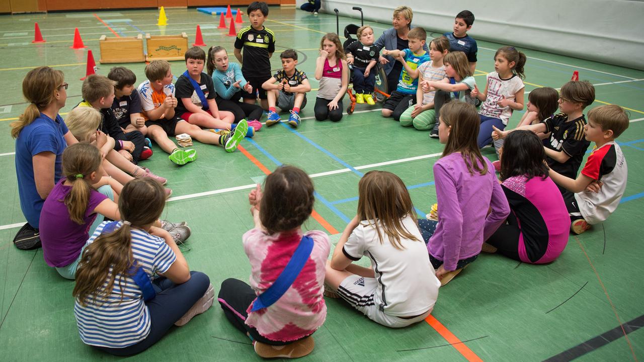 Die niedersächsische Kultusministerin Frauke Heiligenstadt (SPD, Hintergrund Mitte) sitzt am 27.04.2016 in der Sporthalle der Schule IGS Roderbruch in Hannover (Niedersachsen) während einer inklusiven Sportstunde mit Schülern in einem Kreis. Die niedersächsische Kultusministerin Frauke Heiligenstadt (SPD, Hintergrund Mitte) sitzt am 27.04.2016 in der Sporthalle der Schule IGS Roderbruch in Hannover (Niedersachsen) während einer inklusiven Sportstunde mit Schülern in einem Kreis.