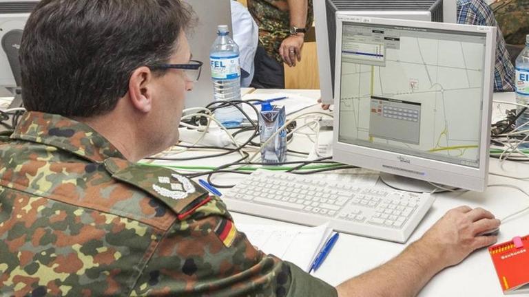 Ein Bundeswehrsoldat sitzt an einem Computer
