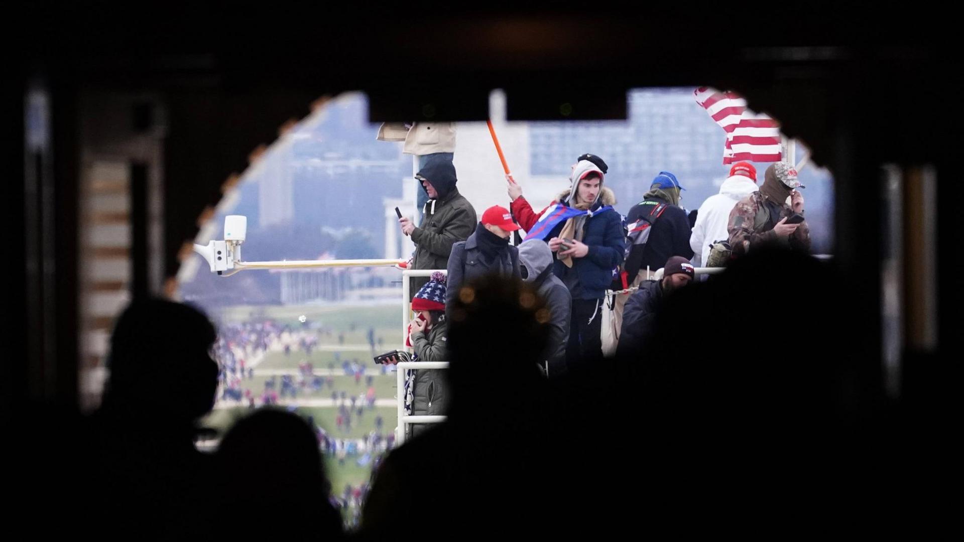 Pro-Trump-Demonstranten am Kapitol in Washington haben ein Gerüst erklettert. Pro-Trump-Demonstranten am Kapitol in Washington haben ein Gerüst erklettert.