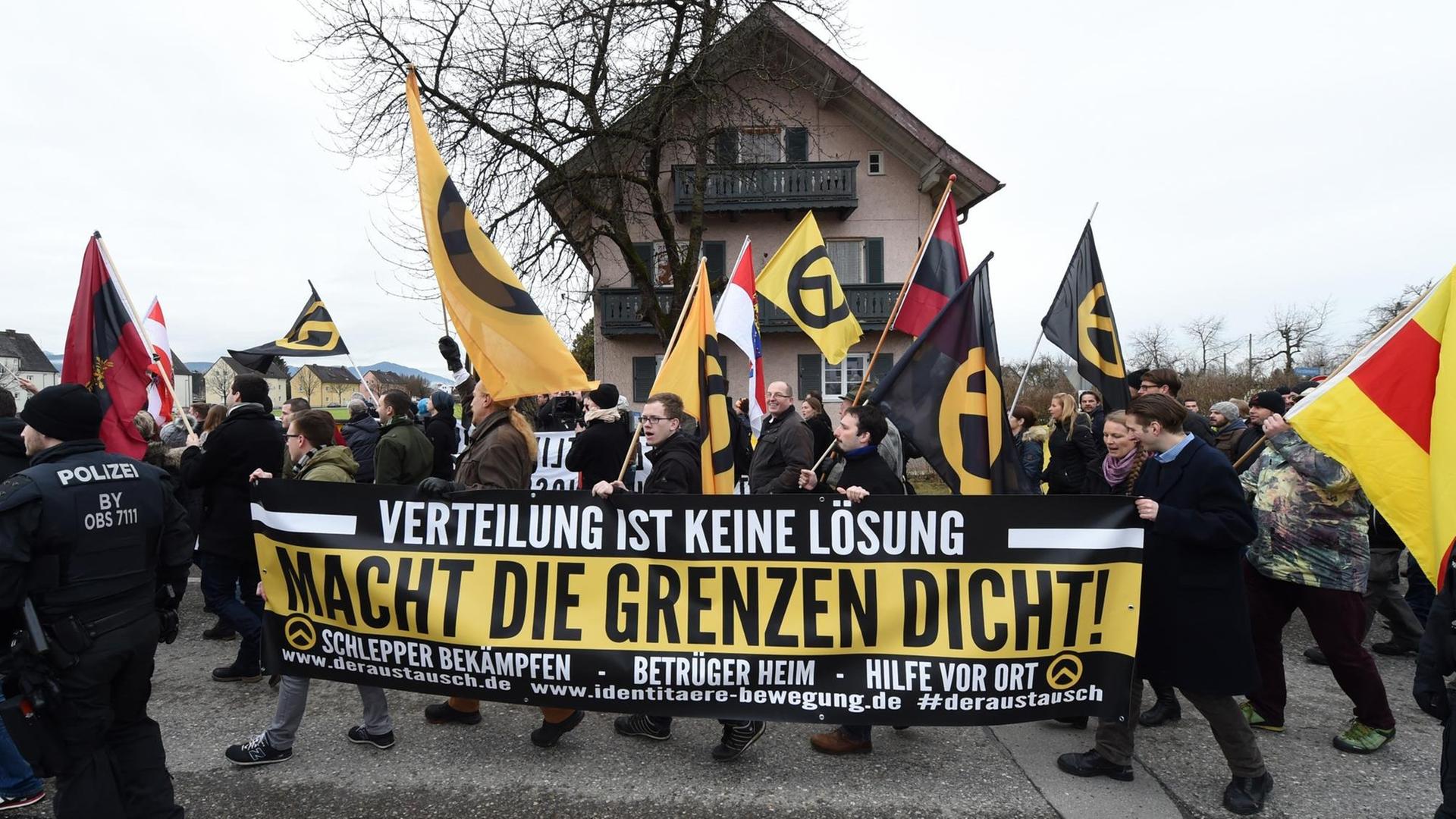 Demonstranten tragen am 09.01.2016 bei Freilassing (Bayern) bei einer Kundgebung ein Transparent mit der Aufschrift "Verteilung ist keine Lösung macht die Grenzen dicht!". Demonstranten tragen am 09.01.2016 bei Freilassing (Bayern) bei einer Kundgebung ein Transparent mit der Aufschrift "Verteilung ist keine Lösung macht die Grenzen dicht!".