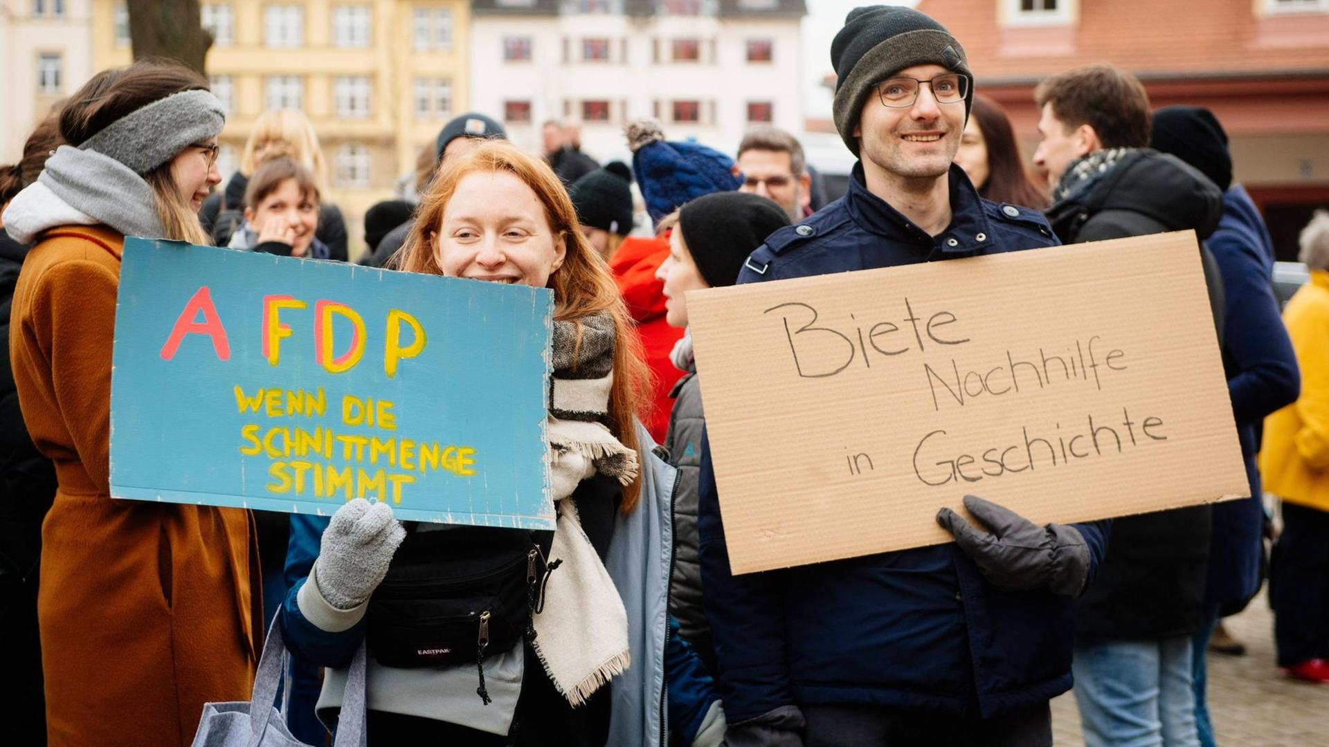 Demonstranten nach der Ministerpräsidentenwahl vor der Thüringer Staatskanzlei in Erfurt. Sie halten Schilder mit den Aufschriften „AFDP – wenn die Schnittmenge stimmt“ und „Biete Nachhilfe in Geschichte“.