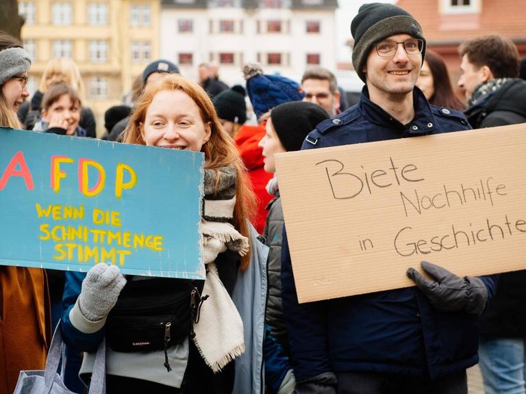 Demonstranten nach der Ministerpräsidentenwahl vor der Thüringer Staatskanzlei in Erfurt. Sie halten Schilder mit den Aufschriften „AFDP – wenn die Schnittmenge stimmt“ und „Biete Nachhilfe in Geschichte“.