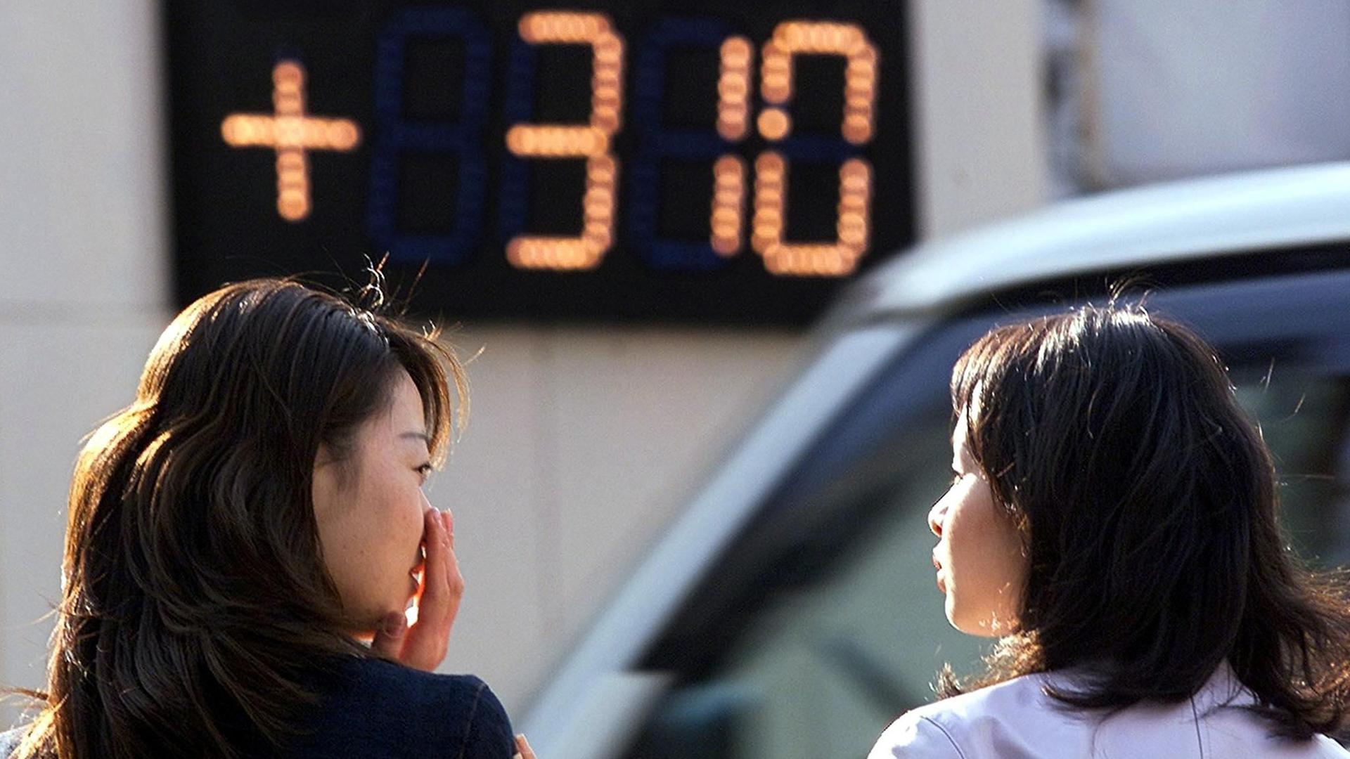 Japanische Frauen beachten Börseninformationen in Tokio.