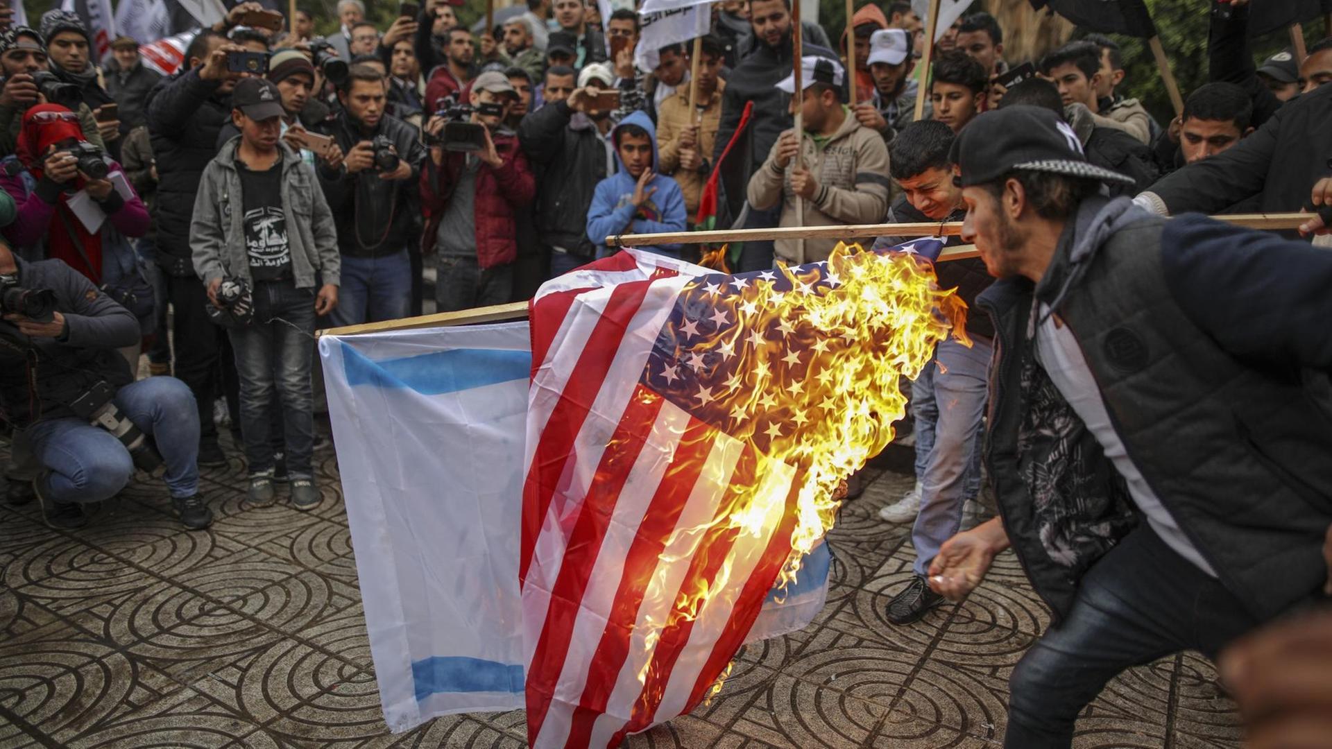 Palästinenser verbrennen am 6.12.2017 in Gaza (Palästinensische Autonomiegebiete) die amerikanische und israelische Flagge. Palästinenser verbrennen am 6.12.2017 in Gaza (Palästinensische Autonomiegebiete) die amerikanische und israelische Flagge.