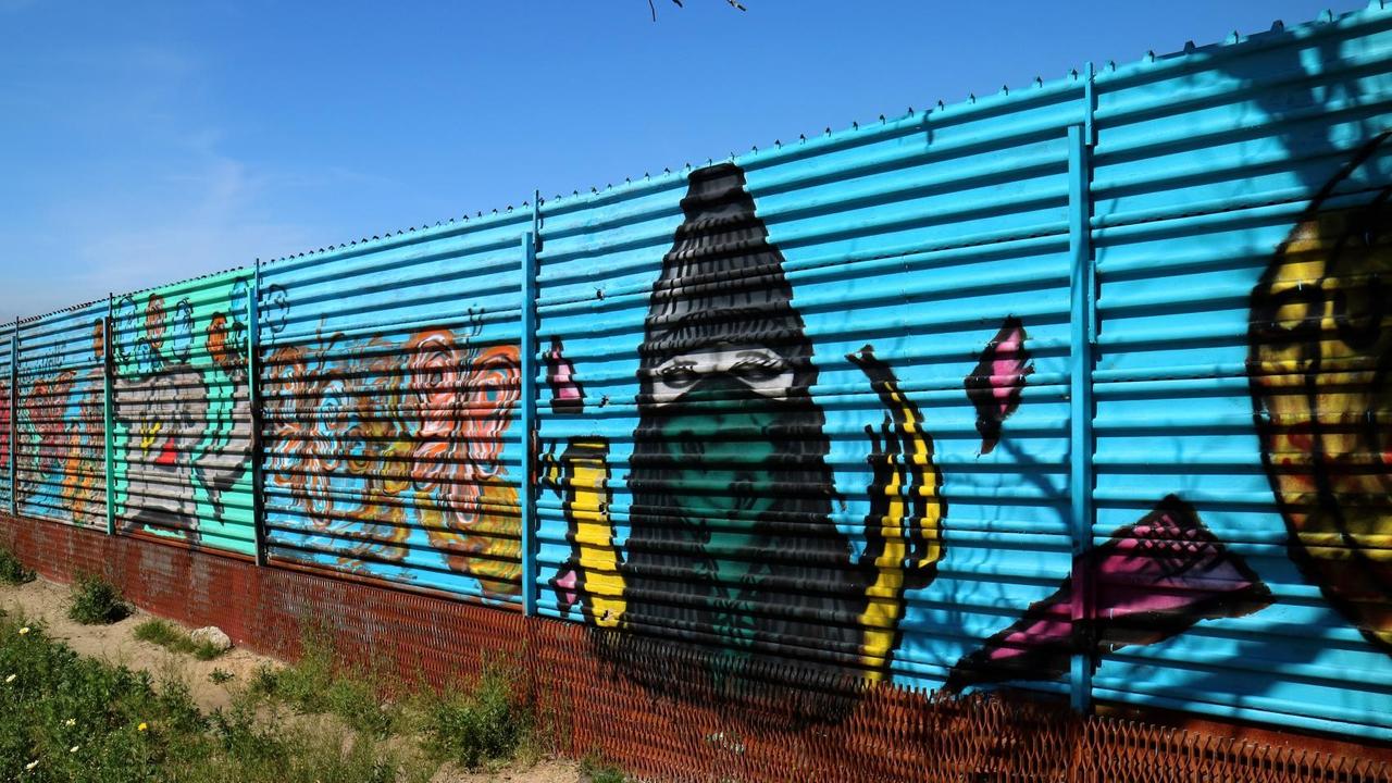 Das Bild zeigt den Grenzzaun aus Metall zwischen Mexiko und den USA, hier im mexikanischen Tijuana. Der Zaun ist bunt bemalt. Das Bild zeigt den Grenzzaun aus Metall zwischen Mexiko und den USA, hier im mexikanischen Tijuana. Der Zaun ist bunt bemalt.