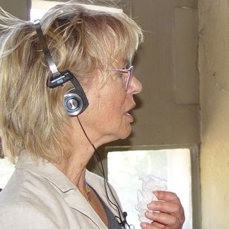 Die Autorin Margot Overath im Profil mit Kopfhörer. 