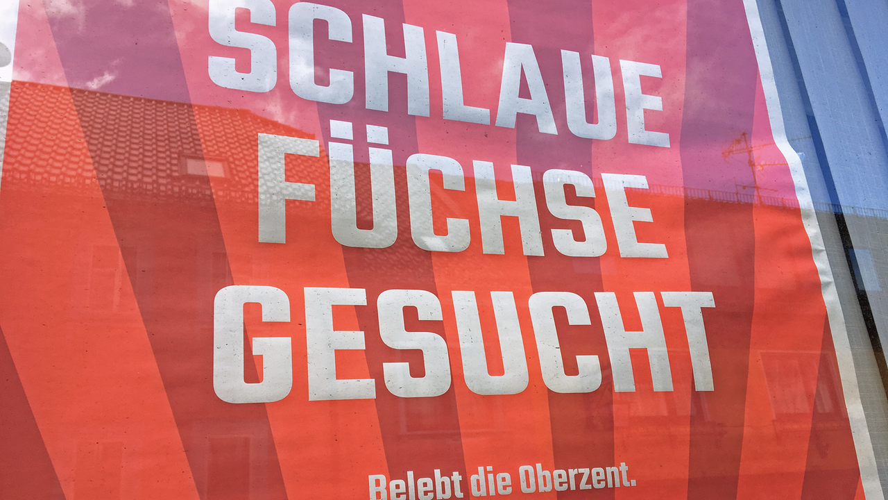 Ein orange-rotes Werbeplakat mit der Aufschrift "Schlaue Füchse gesucht - Belebt die Oberzent." Ein orange-rotes Werbeplakat mit der Aufschrift "Schlaue Füchse gesucht - Belebt die Oberzent."