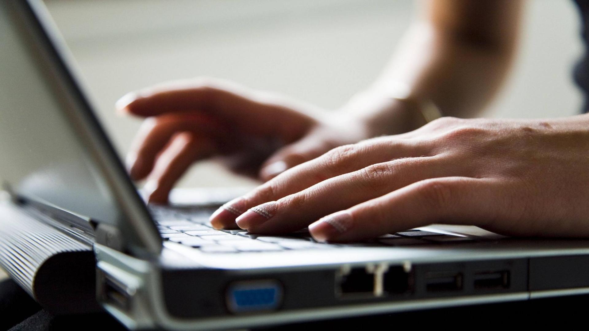 Lackierte Frauenhände tippen auf einerLaptoptastatur Lackierte Frauenhände tippen auf einerLaptoptastatur