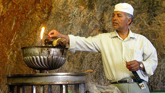 Ein Anhänger der zoroastrischen Religion entzündet eine Flamme in einem iranischen Tempel. Ein Anhänger der zoroastrischen Religion entzündet eine Flamme in einem iranischen Tempel.
