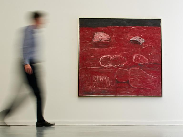 Ein Besucher der Austellung des US-amerikanischen Künstlers Philip Guston geht am 30.04.2014 an dem Gemälde "The Light" (1975) des Künstlers in der Galerie Aurel Scheibler in Berlin vorbei.