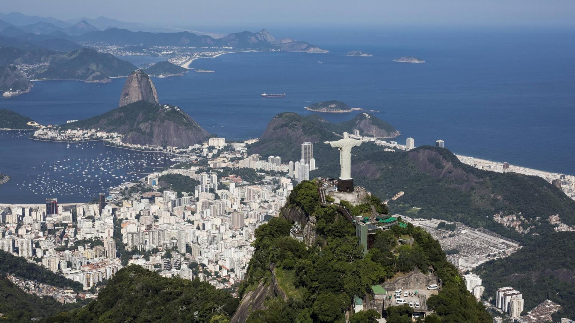 Luftaufnahme von Rio de Janeiro mit der Christusstatue im Vordergrund, der Rio und dem Zuckerhut dahinter und am Horizont das Meer. Luftaufnahme von Rio de Janeiro mit der Christusstatue im Vordergrund, der Rio und dem Zuckerhut dahinter und am Horizont das Meer.