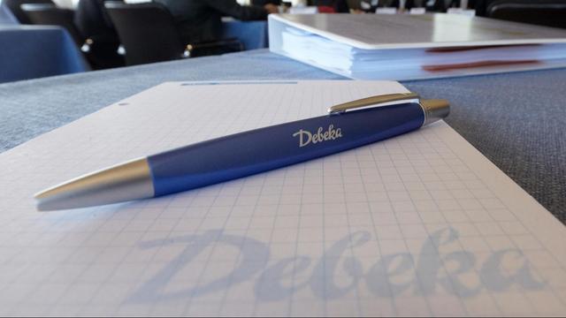 Ein Block und ein Kugelschreiber mit Firmenschriftzug liegen bei der Bilanz-Pressekonferenz des Versicherungsunternehmens Debeka in Koblenz auf dem Tisch.