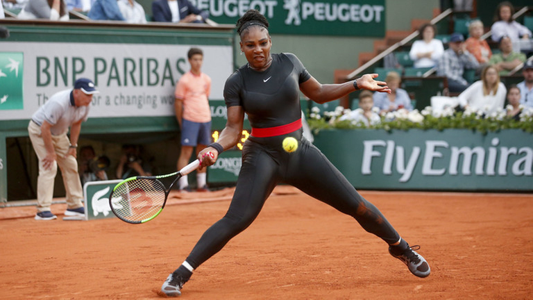 Die Tennis-Spielerin Serena Williams steht mit Tennis-Schläger auf dem Platz.