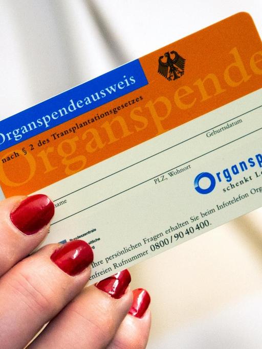 Eine Frau zeigt im Universitätsklinikum Schleswig-Holstein einen Organspendeausweis