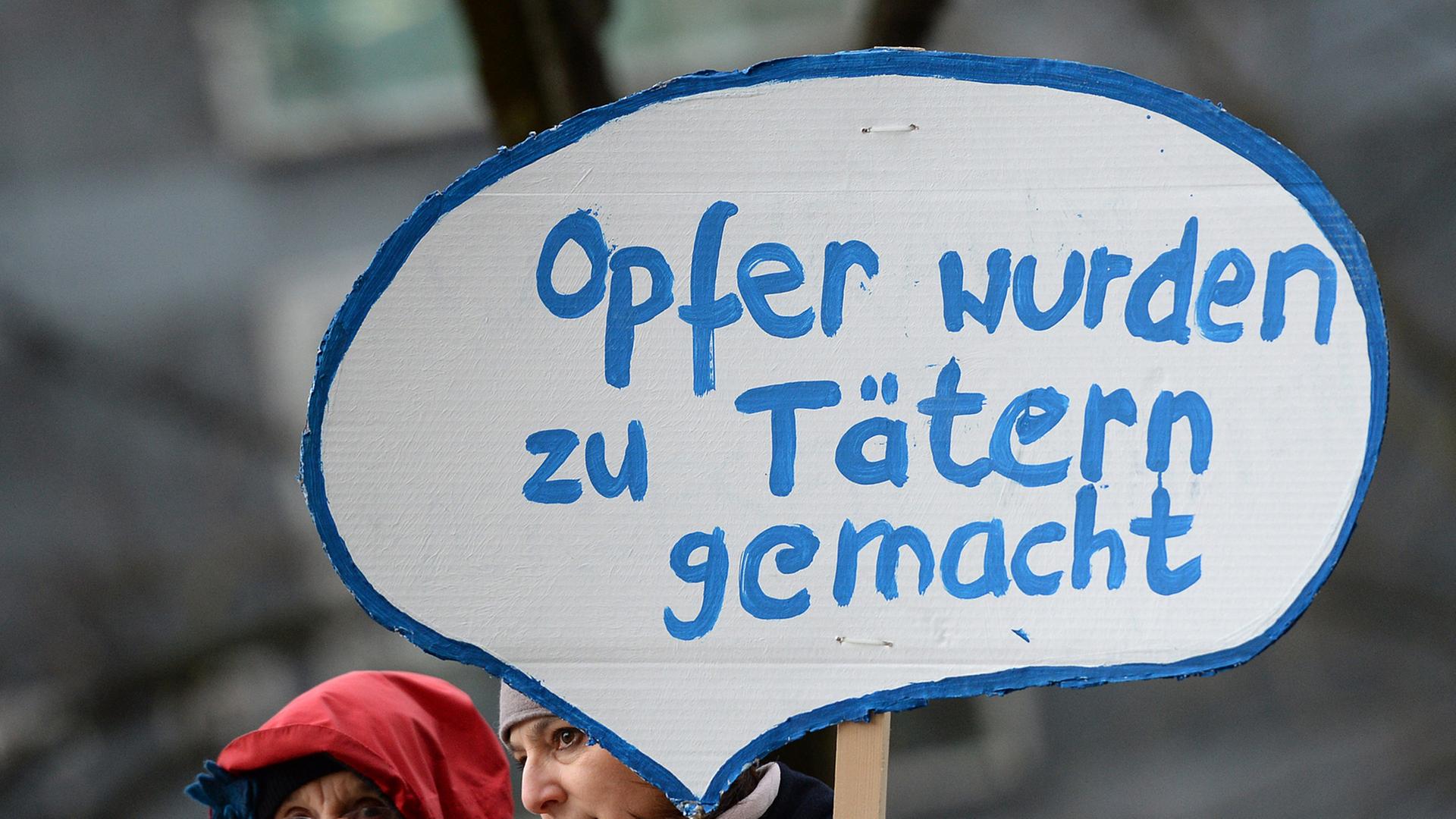 Zwei Frauen mit Schild mit der Aufschrift "Opfer wurden zu Tätern gemacht" Zwei Frauen mit Schild mit der Aufschrift "Opfer wurden zu Tätern gemacht"