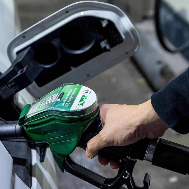 Ein Autofahrer tankt ein Auto mit Benzin Super E5 an einer Tankstelle.