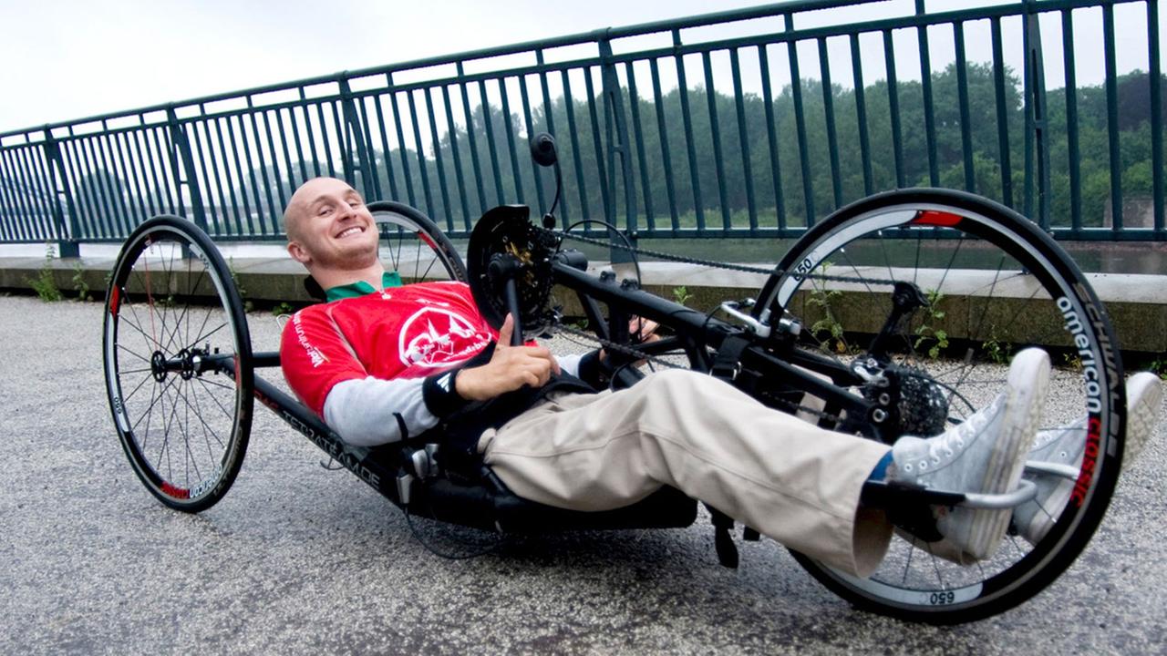 Der Behindertensportler Jens Sauerbier sitzt in Magdeburg an der Elbe in seinem Handbike.