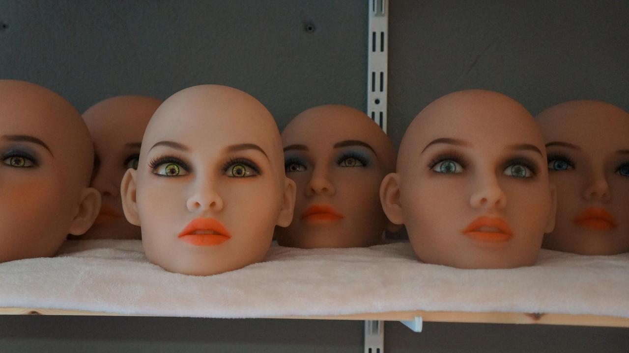 Die Köpfe von Sexpuppen liegen aufgereiht auf einem Regal. Die Köpfe von Sexpuppen liegen aufgereiht auf einem Regal.
