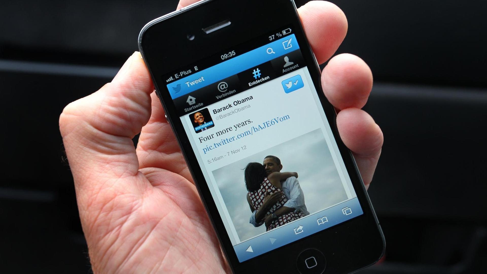 Smartphone auf dessen Display die Twitter-Nachricht "Four more years" von Barack Obama angezeigt wird. Smartphone auf dessen Display die Twitter-Nachricht "Four more years" von Barack Obama angezeigt wird.