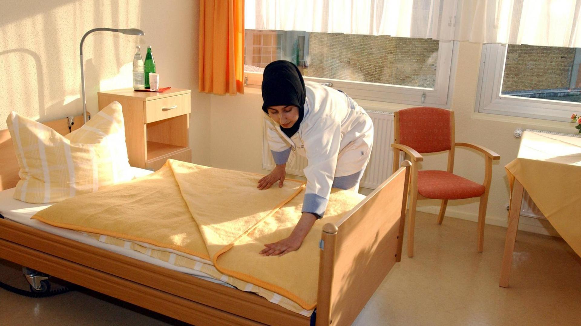 Muslimische Altenpflegerin richtet ein Bett im einem türkischen Altenpflegeheim in Berlin. Muslimische Altenpflegerin richtet ein Bett im einem türkischen Altenpflegeheim in Berlin.
