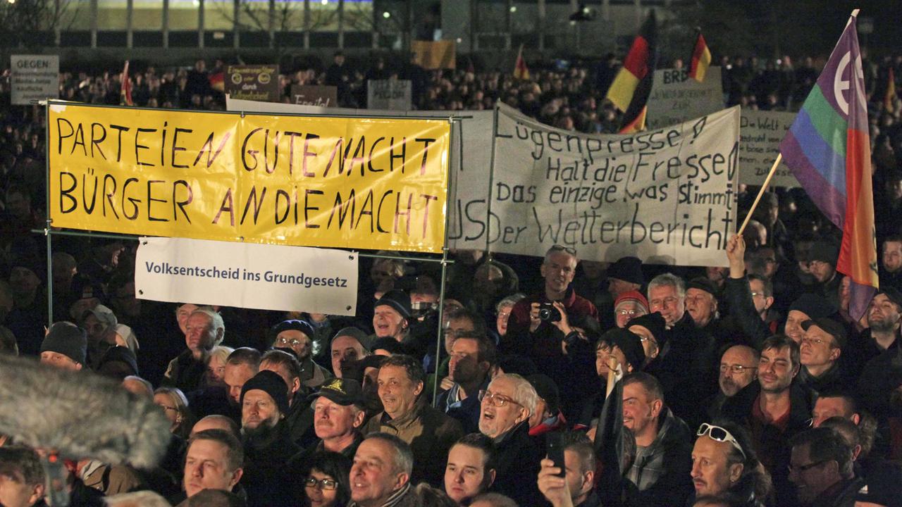 Pegida-Demonstranten in Dresden halten am 15. Dezember 2014 Banner hoch. Pegida-Demonstranten in Dresden halten am 15. Dezember 2014 Banner hoch.