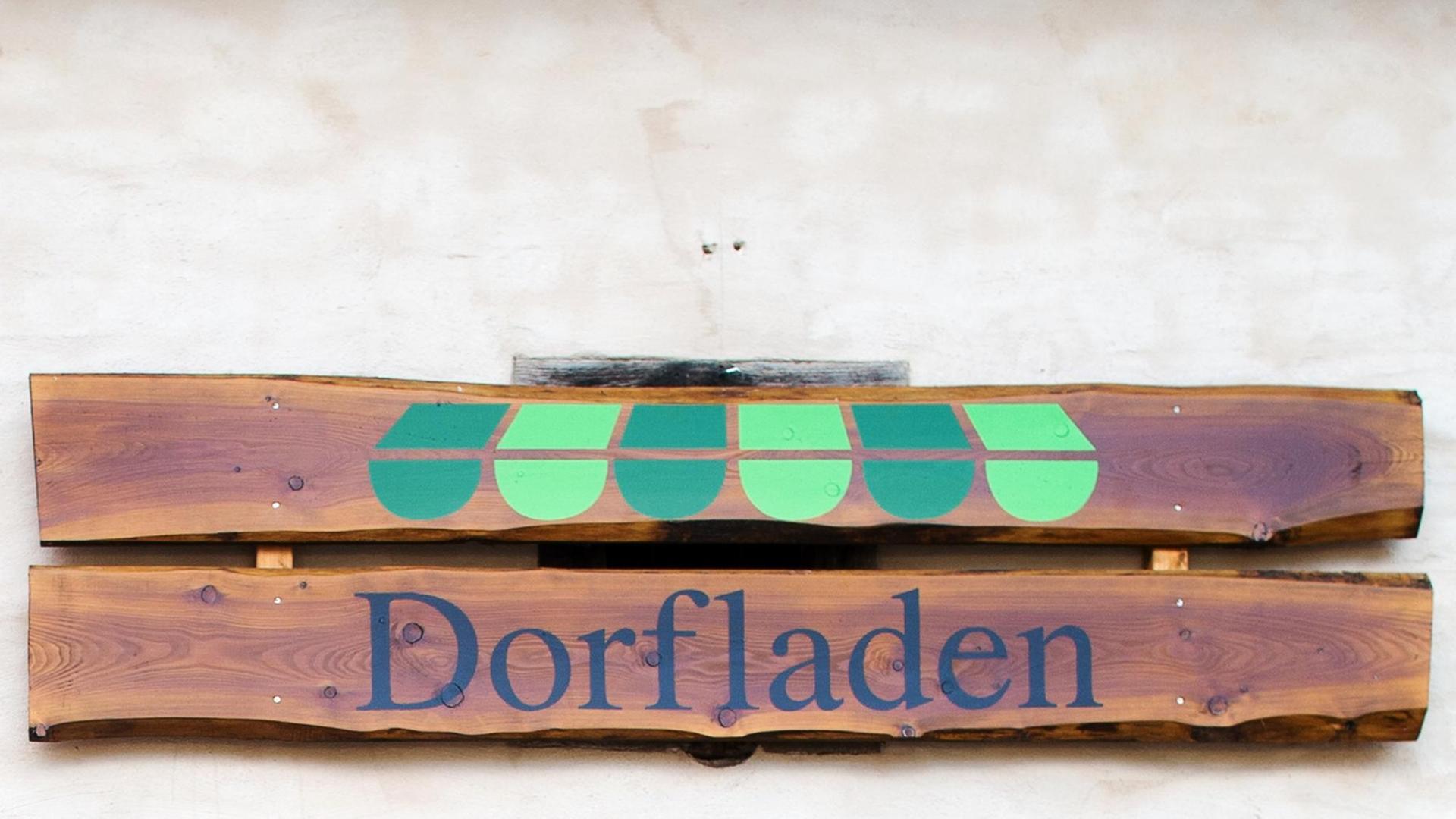 "Dorfladen" steht auf dem Holzschild einer Hausfassade. "Dorfladen" steht auf dem Holzschild einer Hausfassade.