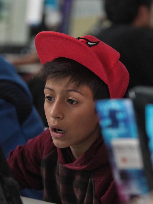 Ein Junge sitzt erstaunt vor einem Computerbildschirm.
