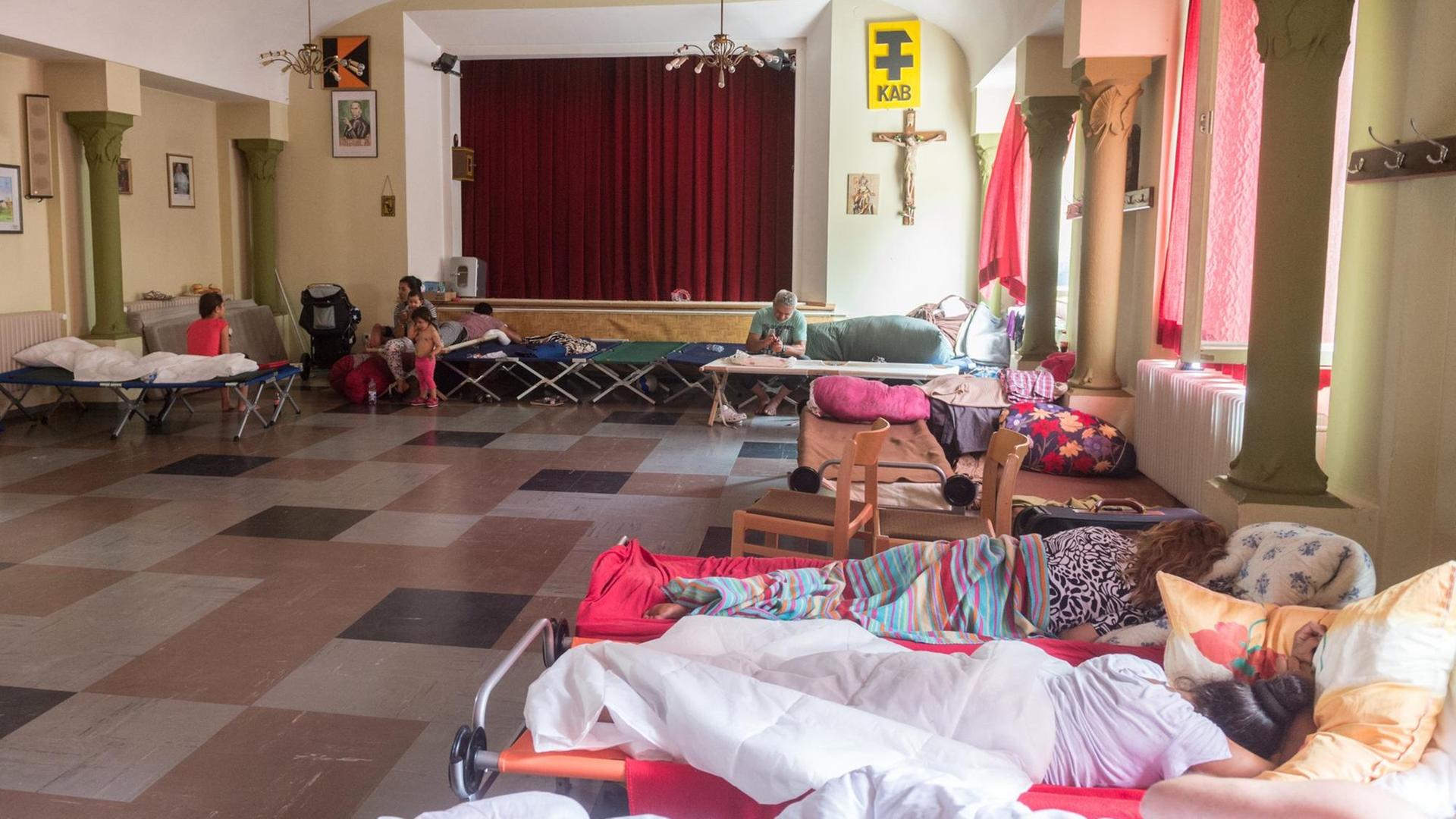 Betten stehen in einem großen Raum eines Pfarrheims in Regensburg. Betten stehen in einem großen Raum eines Pfarrheims in Regensburg.