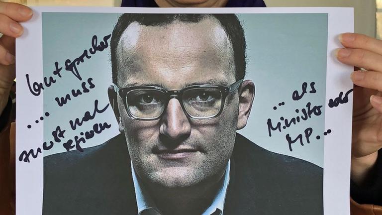 Margaret Heckel hält ein Bild von Jens Spahn hoch, auf das sie etwas geschrieben hat. Margaret Heckel hält ein Bild von Jens Spahn hoch, auf das sie etwas geschrieben hat.