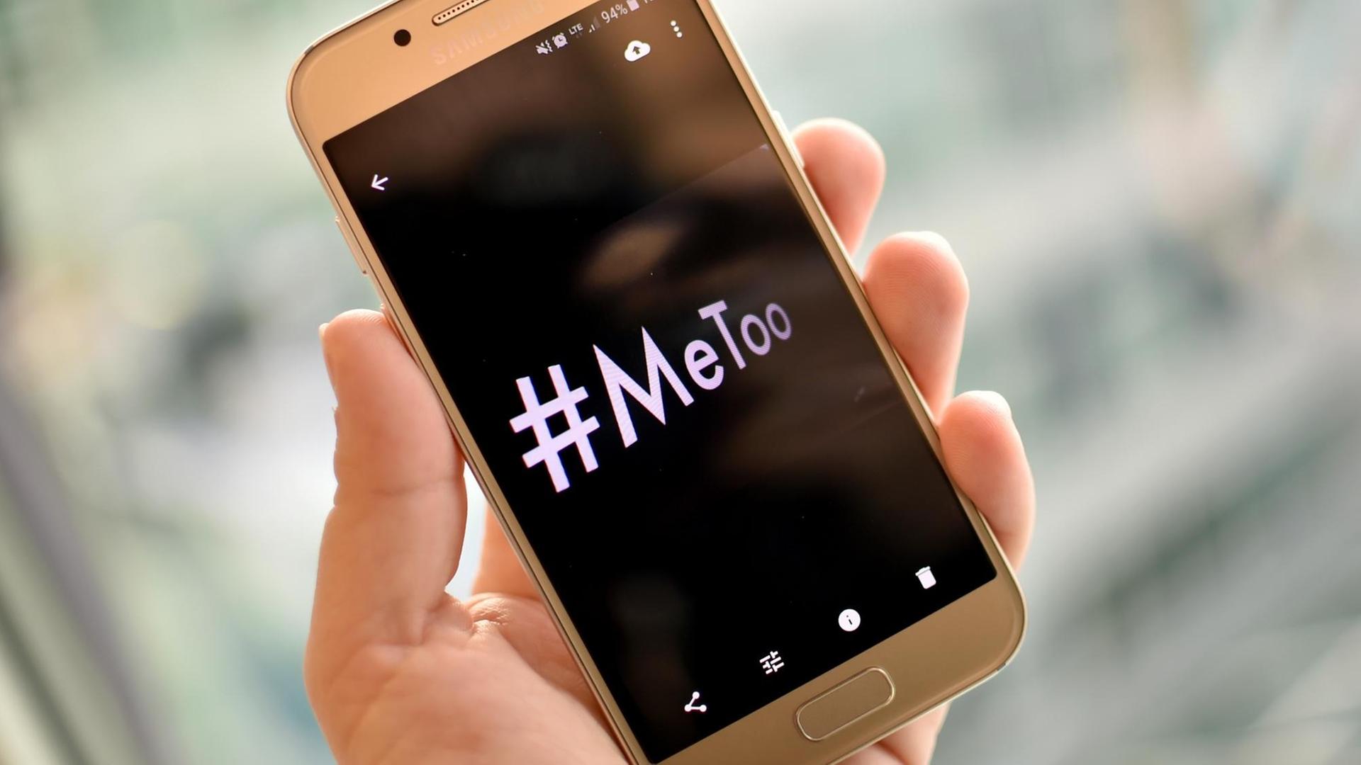 Eine junge Frau hält ein Smartphone mit dem Hashtag "#MeToo" in der Hand Eine junge Frau hält ein Smartphone mit dem Hashtag "#MeToo" in der Hand