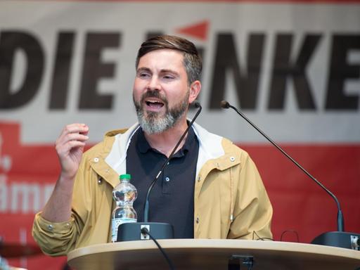 Der Spitzenkandidat der Linken in Hamburg, Fabio De Masi, spricht am 01.09.2017 auf einer Bühne in Hamburg. Foto: Daniel Reinhardt/dpa | Verwendung weltweit