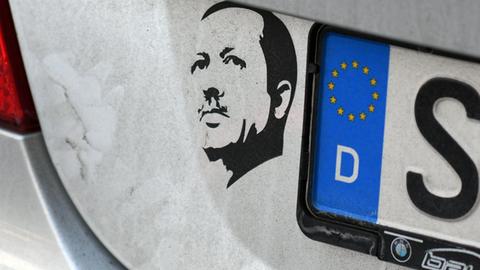 Ein Aufkleber mit dem Konterfei des türkischen Präsidenten Recep Tayyip Erdogan klebt am 06.01.2017 in Bonn (Nordrhein-Westfalen) neben dem hinteren Kennzeichen auf einem Auto. Foto: Henning Kaiser/dpa | Verwendung weltweit