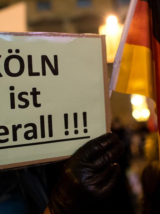 Anhänger der islamkritischen Bewegung Bagida (Bayern gegen die Islamisierung des Abendlandes) in München halten ein Plakat mit der Aufschrift "Köln ist überall" in den Händen. Bagida ist ein regionaler Ableger der islamkritischen Pegida-Bewegung