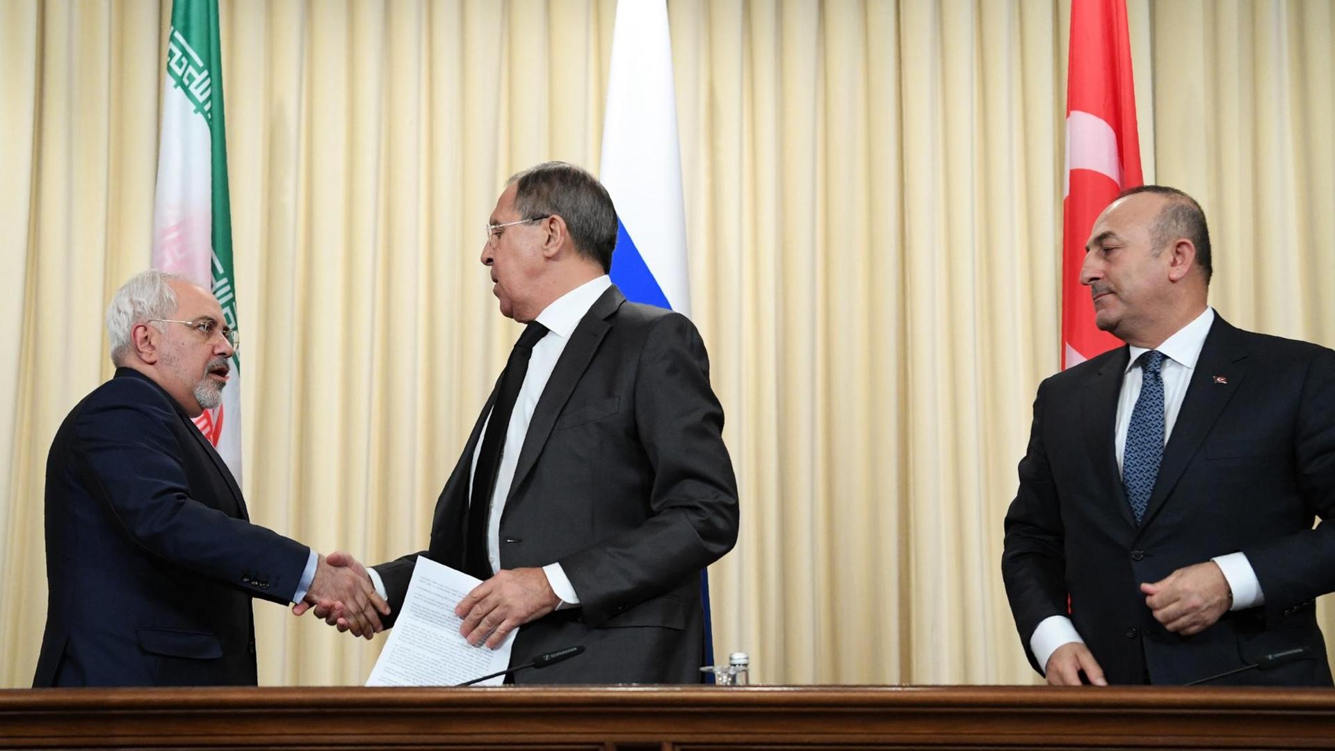 Sergej Lawrow schüttelt Mohammad Javad Zarif die Hand, rechts von den beiden Mevlut Cavusoglu