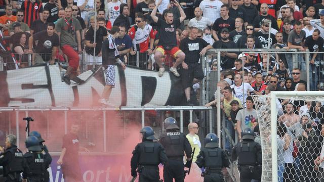 Polizeikräfte gehen nach einem Fußball-Spiel gegen randalierende Fans vor.