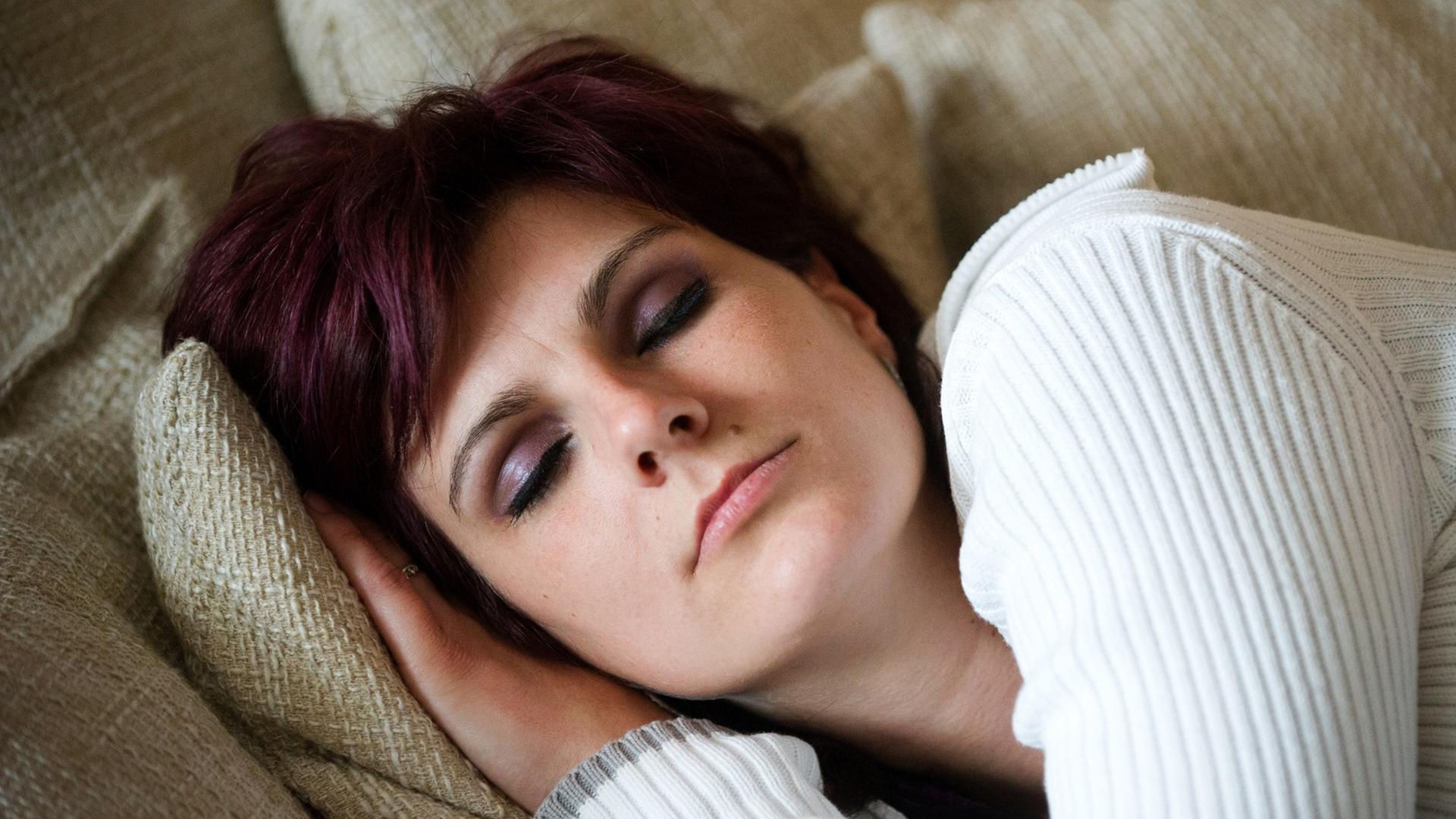 Junge Frau ruht schlafend auf dem Sofa. Junge Frau ruht schlafend auf dem Sofa.