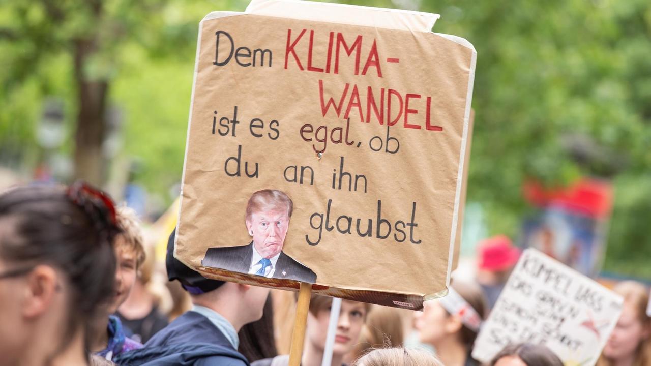 Ein "Fridays For Future"-Demonstrant hält ein Plakat mit der Aufschrift "Dem Klima-Wandel ist es egal, ob du an ihn glaubst" hoch.