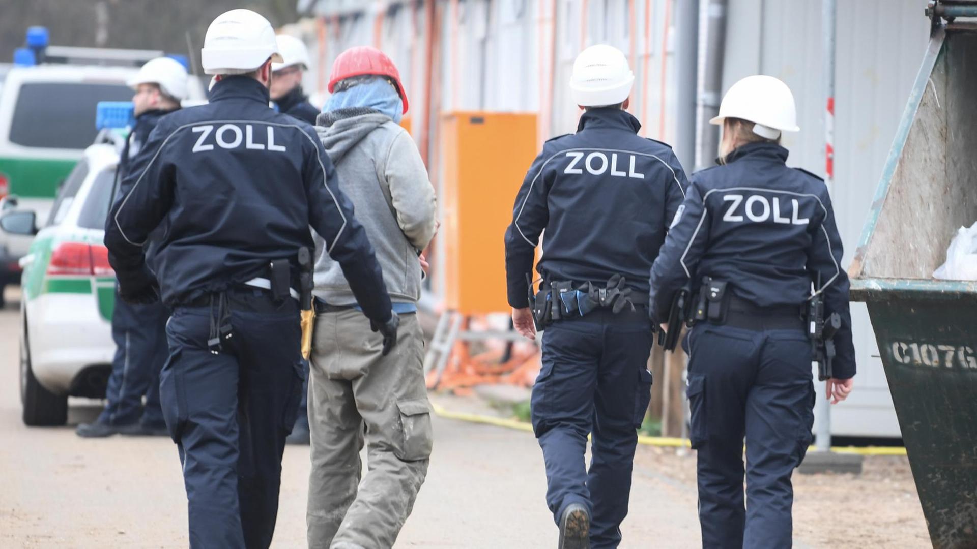 Beamte des Zoll kontrollieren einen Bauarbeiter während eines Einsatzes auf einer Großbaustelle in Frankfurt. Beamte des Zoll kontrollieren einen Bauarbeiter während eines Einsatzes auf einer Großbaustelle in Frankfurt.