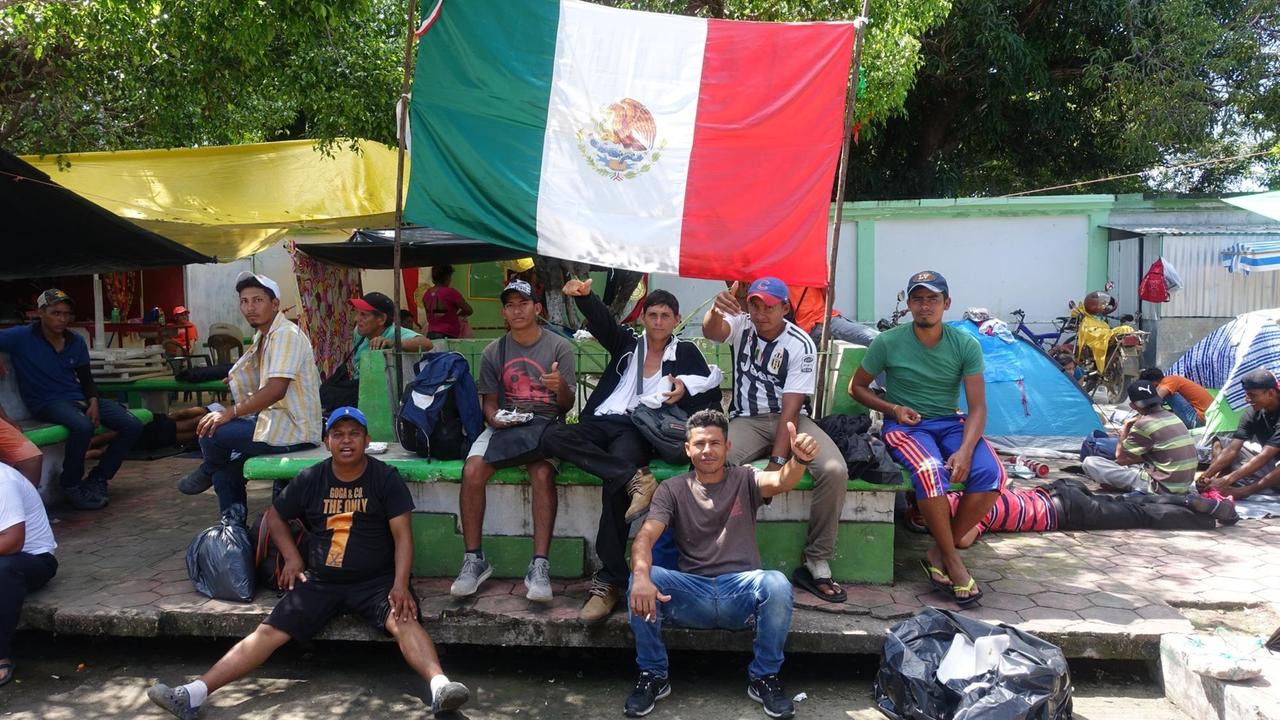 Männer sitzen unter mexikanischer Flagge