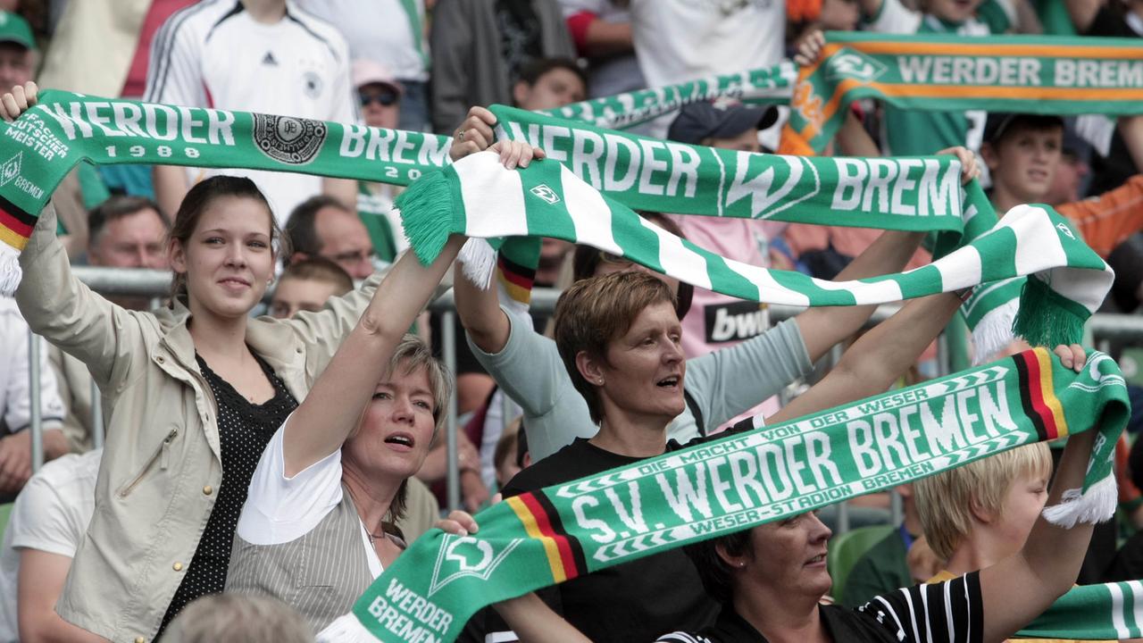 Weibliche Fans von Werder Bremen halten ihre Fanschals in die Höhe. Weibliche Fans von Werder Bremen halten ihre Fanschals in die Höhe.