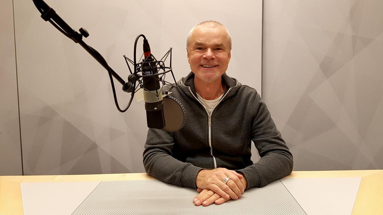 Der Talkmoderator Jürgen Domian sitzt in einem Deutschlandfunk-Studio hinter einem Mikrofon