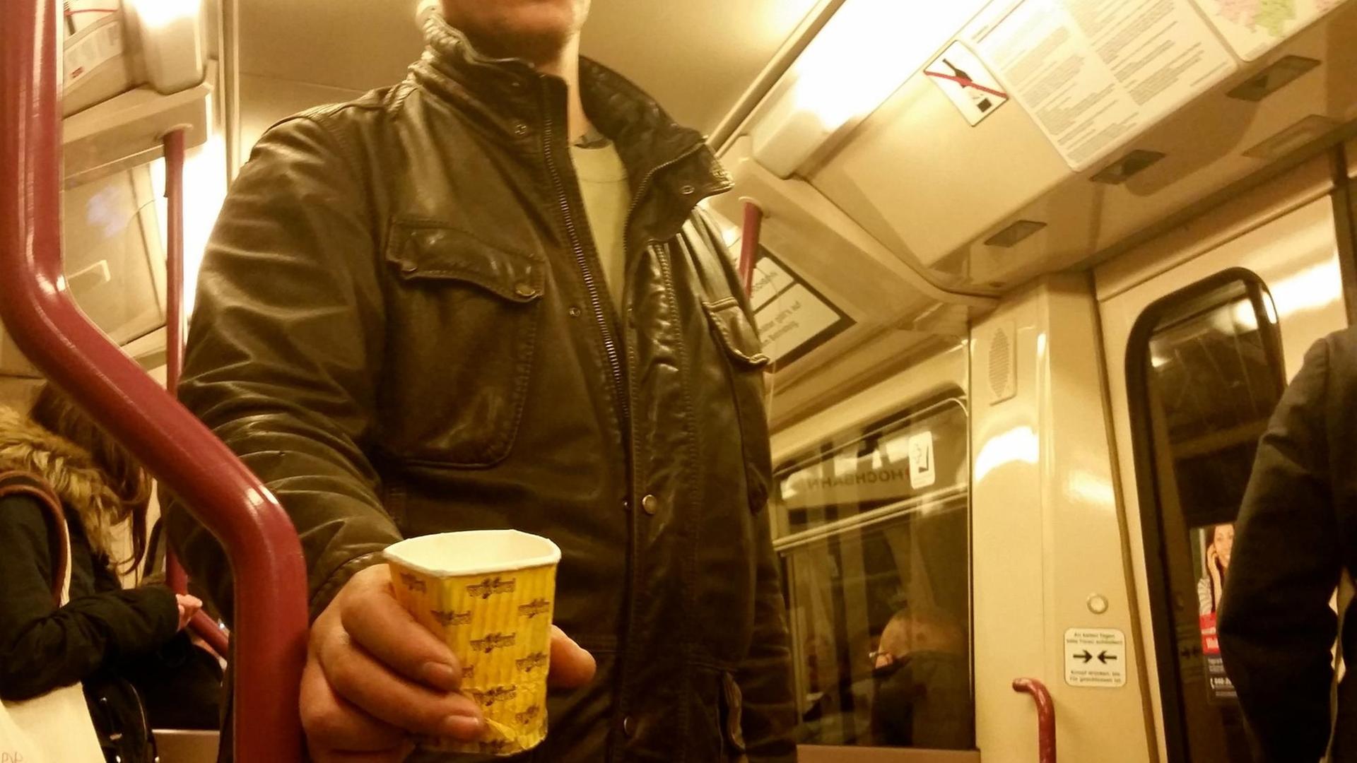 Ein Bettler bittet in einer U-Bahn um eine Geldspende.
